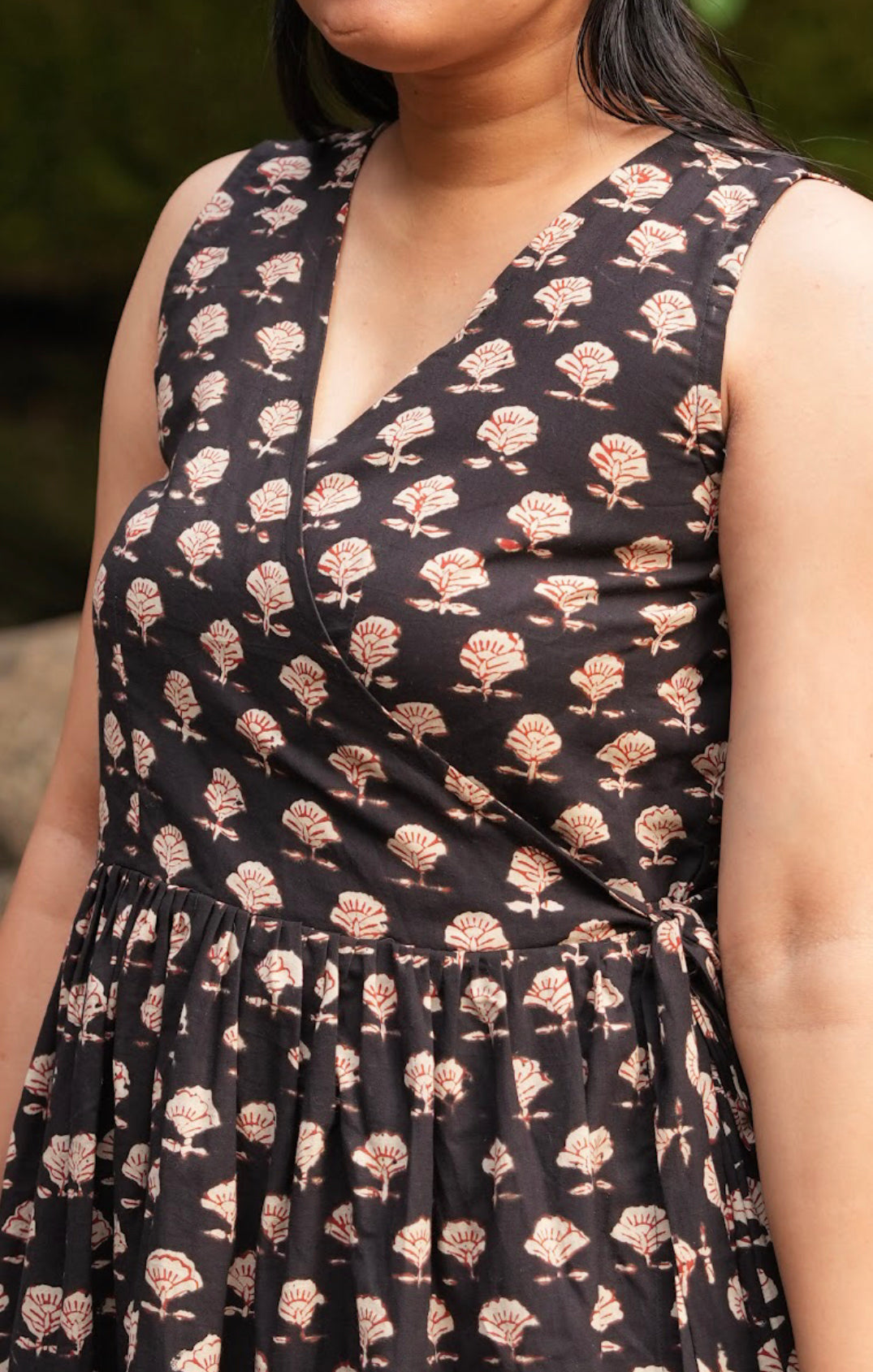 Experience the handcrafted charm of our cotton hand block printed black wrap dress. This wrap dress is midi length and is sleeveless.