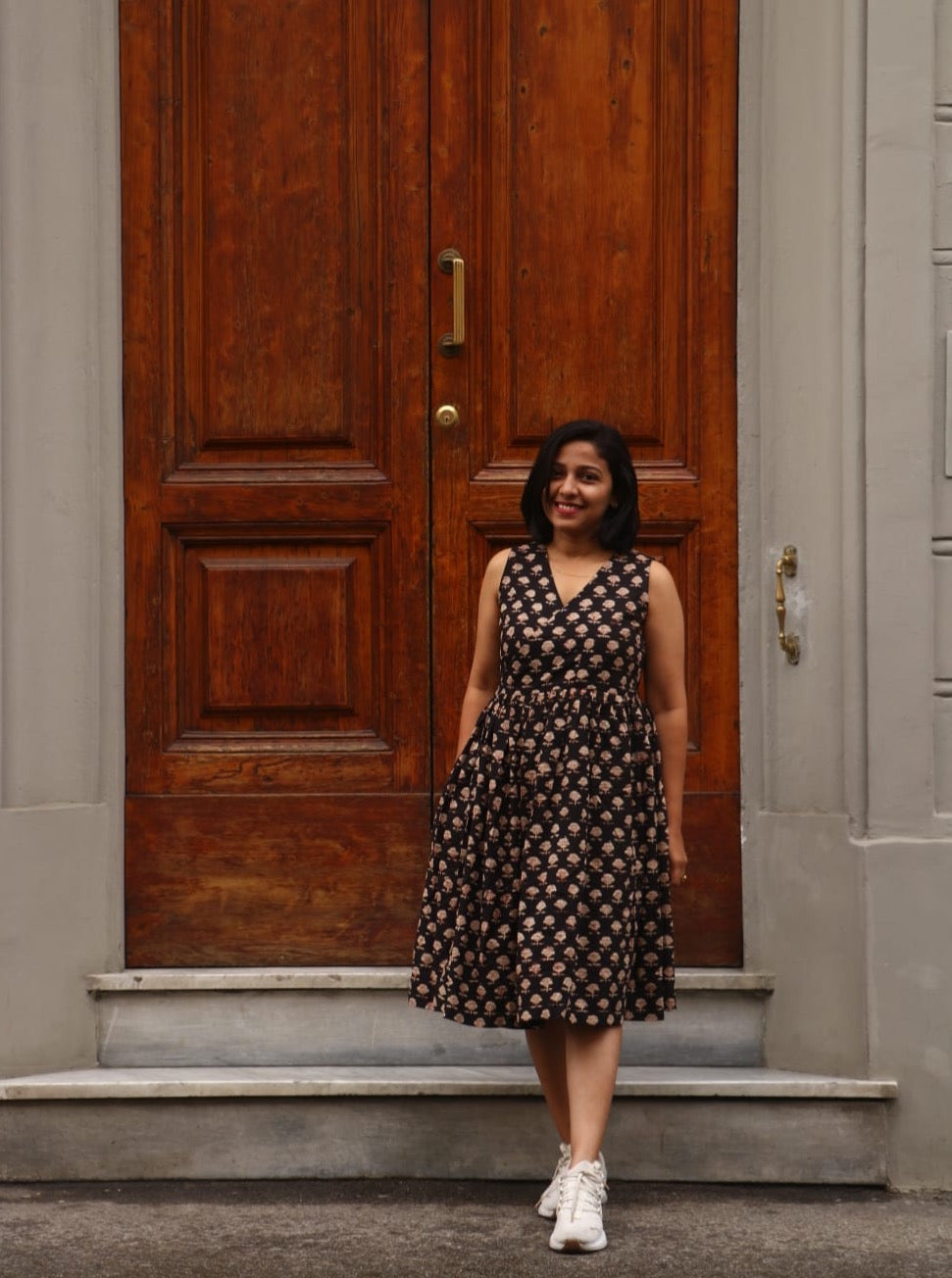 Black hand block printed cotton wrap dress. Sleeveless midi style offers cool comfort for vacations & casual wear. Shop this versatile dress now.